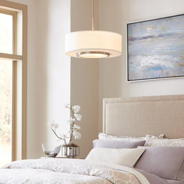light pendant hanging over a bed with a natural color shceme