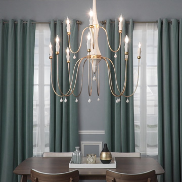 multi-light chandelier hanging in a living room with green curtains