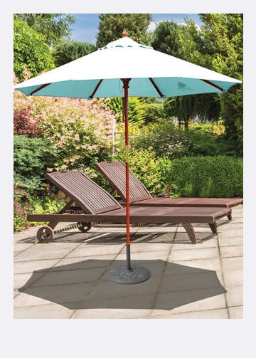 blue patio umbrella on a stone tile deck in front of wooden deck lounge chairs